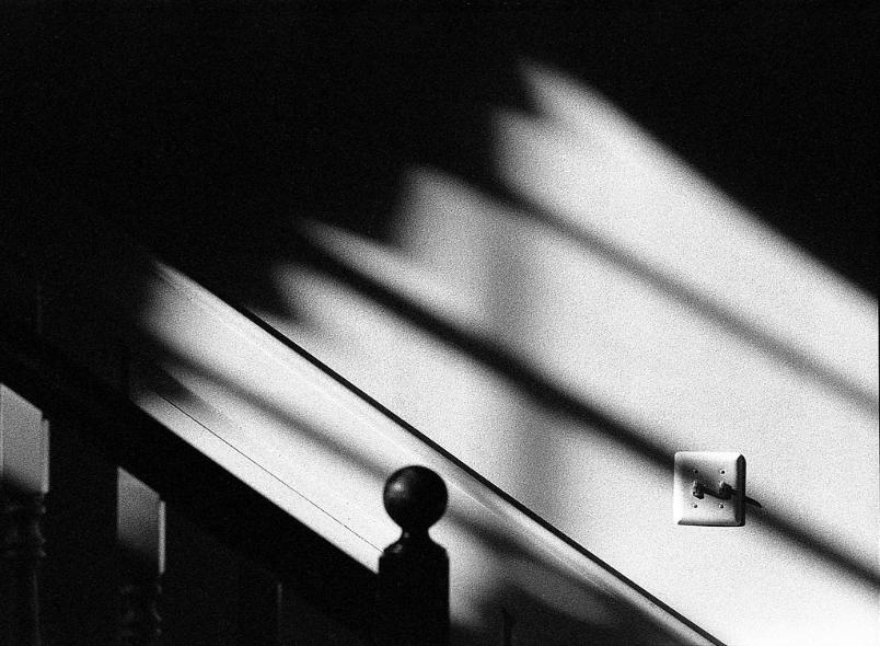 Light Switch Stairs Banister Shadows black and white film photography