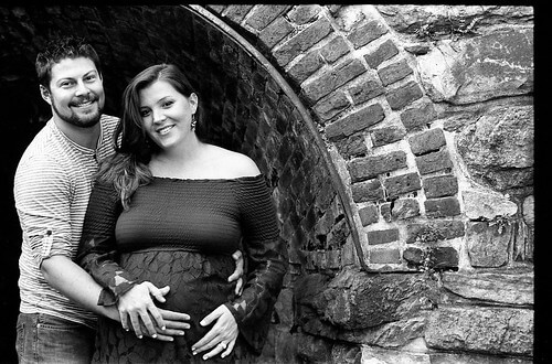 maternity pregnant stone wall rustic portraits portraiture mom dad parents proud new mother father happy young attractive man woman holding stomach holding baby birth johnny martyr leica summarit film black and white family